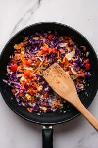 This image shows the cabbage mixture being seasoned with spices and herbs, bringing out the full flavor of the keto cabbage rice.