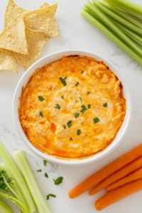 This image shows the Crockpot Buffalo Chicken Dip being served, garnished with additional shredded cheese or herbs, ready to pair with crackers, chips, or fresh veggies.