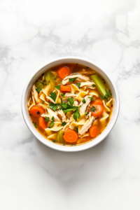 This image shows a hearty bowl of Crockpot Chicken Noodle Soup, garnished with fresh parsley and ready to enjoy.