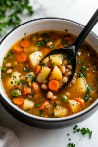 This image shows a warm bowl of Crockpot Vegetable Soup, served with a garnish of parsley and a slice of bread on the side for a comforting meal.