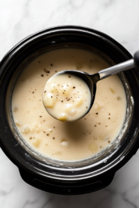 This image shows a ladle pouring the creamy potato soup into a serving bowl, ready to be enjoyed.