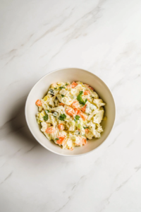 this image shows freshly prepared bowl of low-carb keto coleslaw, showcasing a mix of crunchy vegetables coated in a creamy dressing, served as a healthy and delicious side dish.