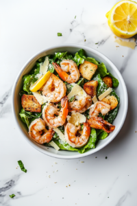 This image shows the completed shrimp Caesar salad being served, showcasing the vibrant ingredients and creamy dressing, ready to be enjoyed.