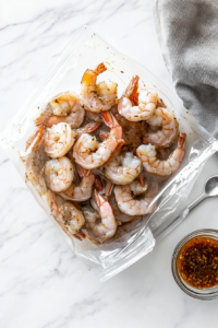 This image shows raw shrimp placed in a bowl of honey garlic marinade, soaking to absorb the sweet and savory flavors.