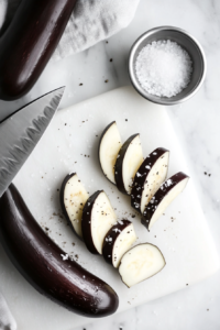 this image shows This image shows an eggplant being sliced into thin pieces, ready to be grilled and layered in the Keto Eggplant Lasagna.