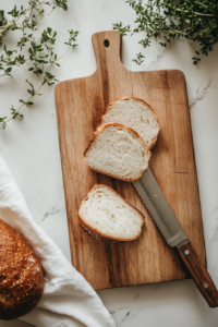 This image shows a loaf of no yeast bread being sliced with a bread knife into even pieces, ready to be served as a warm, crusty treat.