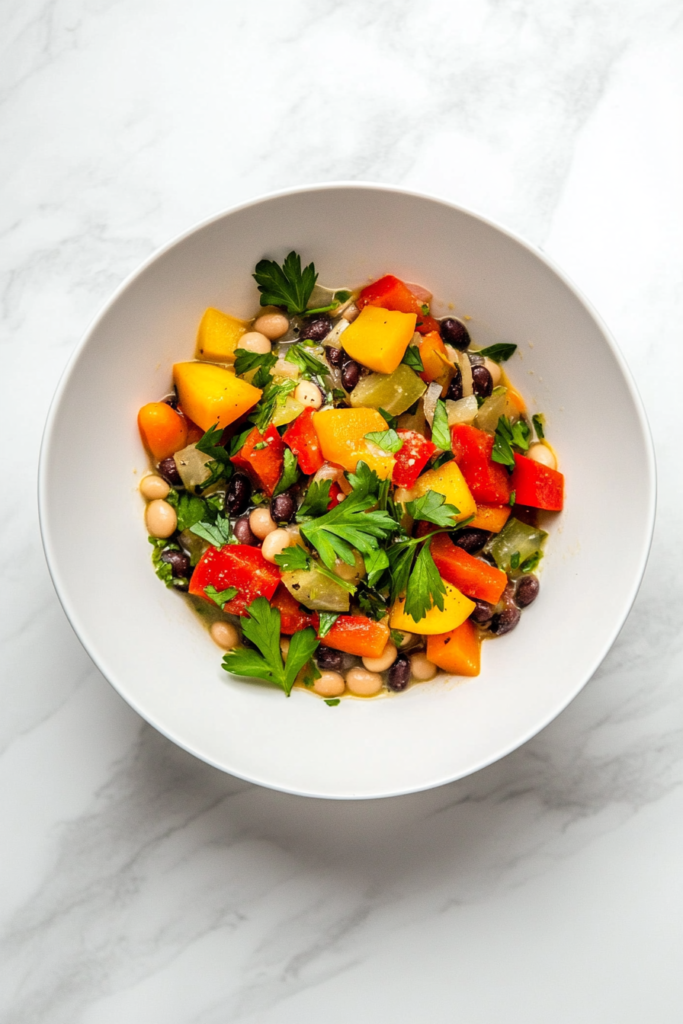 This image displays a wholesome slow-cooked vegetable and bean soup, featuring vibrant bell peppers, tomatoes, and fresh cilantro.