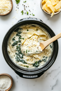 This image shows ingredients, including spinach, artichokes, and shredded cheese, being tossed together inside a slow cooker to evenly mix before cooking.