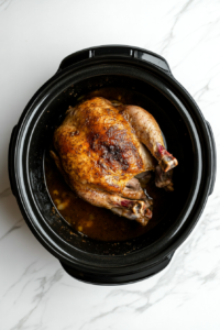 This image shows the seasoned turkey breast carefully positioned in a slow cooker, ready to be cooked to perfection.