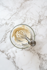 This image shows the French Buttercream being whipped in a stand mixer until smooth, creamy, and ready for spreading.