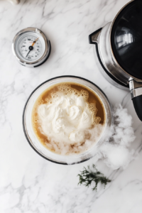 This image shows a bowl of aquafaba being whipped with a mixer to create a fluffy vegan meringue base for topping the pie.