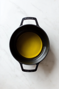 this image shows Olive oil heating up in a large pot, ready to sauté the garlic and Brussels sprouts for the creamy pasta sauce.