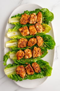 placing-the-sliced-chicken-on-lettuce-leaves-for-wrapping-around