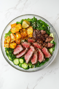 This image shows perfectly cooked steak being sliced into thin strips on a cutting board, ready to top the Steak Cobb Salad.