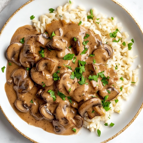 this image shows A creamy cornstarch and plant-based milk mixture being poured into the skillet with mushrooms, onions, and garlic, thickening into a luscious stroganoff sauce.