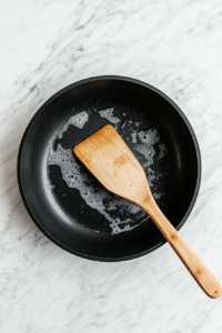 This image shows a skillet being heated on the stove, getting ready for the sautéing process.