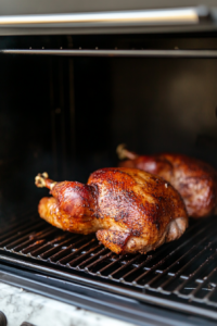 This image shows a digital grill thermometer displaying an increased temperature of 425°F, preparing the turkey pastrami for a final crisp sear.