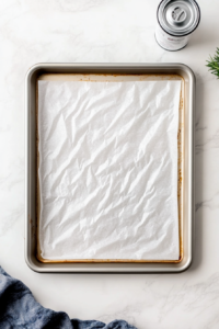 baking-sheets-being-lined-with-parchment-paper-and-oven-preheated-for-baking-witch-finger-cookies