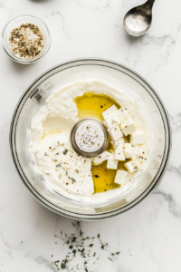 This image shows feta cheese, yogurt, and honey being blended together until smooth and creamy, creating the rich base for whipped feta with honey.