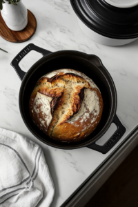 This image shows a covered Dutch oven inside a hot oven, allowing the bread to bake with steam for a crispy crust.