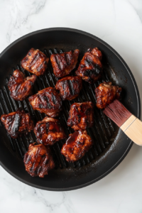 This image shows jerk chicken pieces sizzling on a grill, adding a delicious charred and smoky finish.