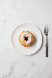 This image shows a plate of cinnamon rolls with a soft, gooey center, topped with luscious icing, ready to be enjoyed as a sweet treat.