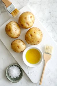 This image shows raw potatoes being evenly coated with olive oil and sprinkled with salt, ensuring a crispy skin and rich flavor before slow cooking.