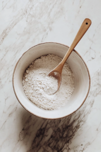 This image shows flour, yeast, and salt being mixed together in a large bowl, the first step in making homemade yeast bread.