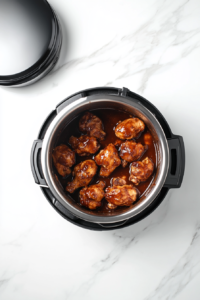 This image shows the marinated chicken inside an Instant Pot, where it is being pressure-cooked for a juicy and flavorful result.