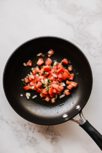 cooking-diced-tomatoes-and-minced-garlic-for-a-flavorful-pasta-sauce