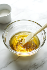 This image shows butter and sugar being mixed together in a bowl, forming a rich and creamy base for the crustless apple pie batter.