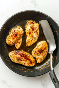 This image shows sandwich buns being toasted on a pan until golden brown, adding a warm and slightly crispy texture to the Honey Pepper Pimento Chicken Sandwich.