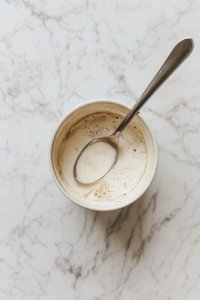 This image shows a bowl of freshly prepared glaze cooling to the perfect consistency before being drizzled over the cake.