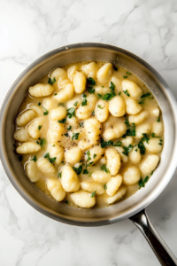 This image shows soft gnocchi cooking in a pot of boiling water until they float to the top, indicating they are ready.