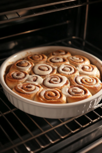 This image shows cinnamon rolls fresh out of the oven, perfectly baked to a golden brown with a soft, fluffy interior.