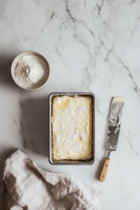 This image shows a loaf pan lightly greased and lined with parchment paper, ready for the cranberry orange loaf batter to be poured in.