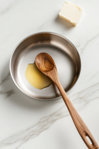 This image shows a pan with olive oil and butter melting together, creating a rich base for cooking the turmeric rice.