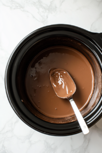 This image shows the hot chocolate after two hours of slow cooking in the crockpot, with a rich, creamy texture and deep chocolate color, ready for garnishing.