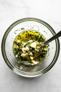 This image shows butter melting in a pan as minced garlic is stirred in, creating a fragrant and flavorful garlic butter base for the creamy shrimp rigatoni.