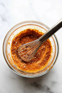 This image shows flour being mixed with spices in a bowl to create the perfect coating for crispy fried chicken.