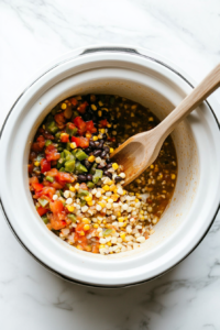 This image shows the sautéed onion, garlic, and spice mixture being transferred to a slow cooker, ensuring even cooking for a flavorful taco soup.