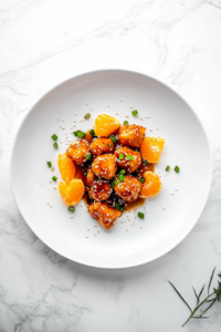 This image shows a beautifully plated serving of PF Chang's Orange Chicken, garnished with toasted sesame seeds and fresh green onions, ready to be enjoyed.