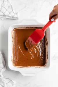 The smooth pecan bread batter being poured into a greased baking dish, ready for baking.