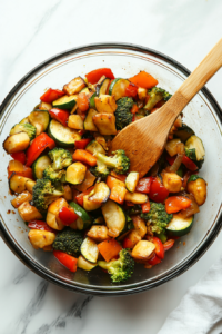 This image shows a rich chicken broth being poured into a pan filled with stir-fried vegetables, allowing the flavors to blend and intensify as the mixture simmers.