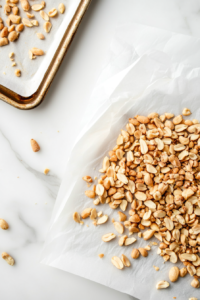 This image shows a countertop neatly lined with parchment paper, ready to hold freshly made crockpot peanut clusters as they set and cool.