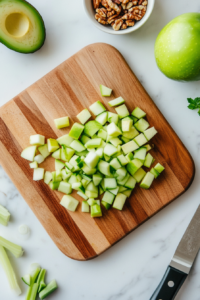 This image shows fresh ingredients like apples and vegetables being chopped and prepared for the tuna salad, adding crunch and flavor to the dish.