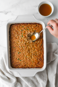 This image shows grease being carefully drained from the baked turkey meatloaf before assembling the casserole.