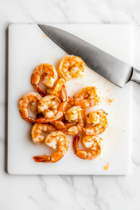 This image shows shrimp tails being carefully chopped off, ensuring a smooth and easy eating experience for the Bang Bang Chicken and Shrimp dish.