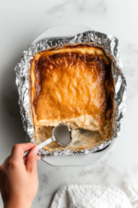 removing-foil-from-baked-casserole-to-reveal-creamy-top-layer