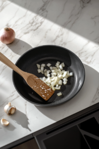 This image shows onions and garlic being sautéed in a pan, creating a fragrant and flavorful base for the crockpot stew.